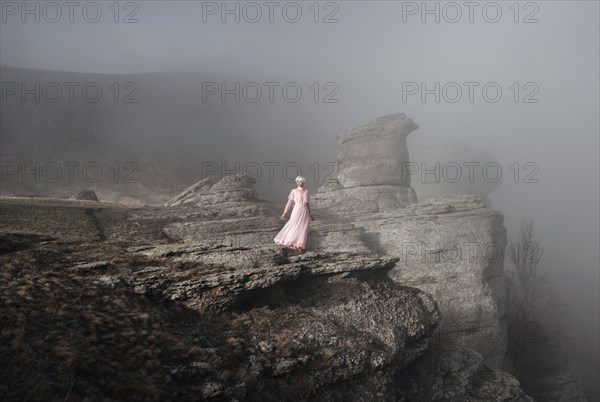 Caucasian woman standing on misty rock formation