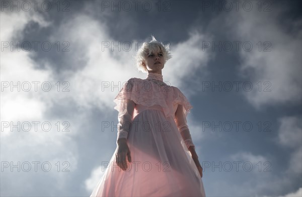 Caucasian woman walking under cloudy sky