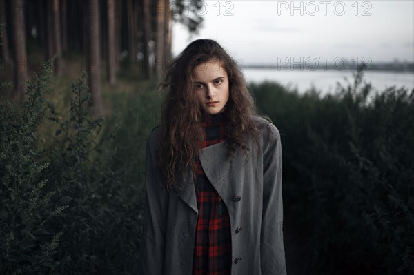 Caucasian woman standing in woods near lake