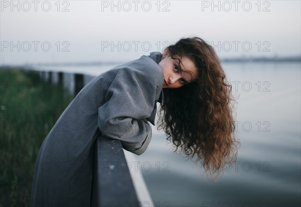 Caucasian woman leaning over river wall