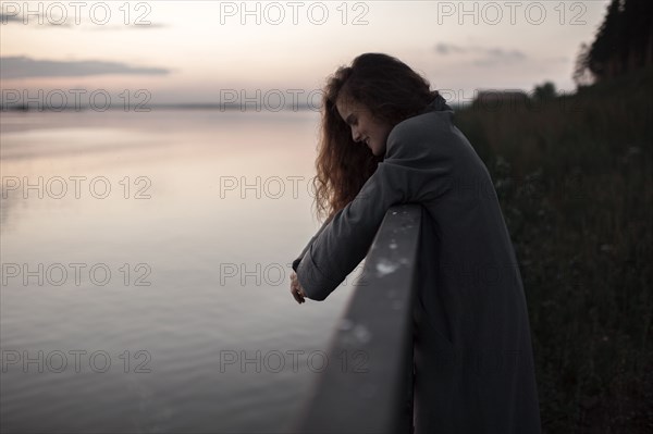 Caucasian woman leaning over river wall