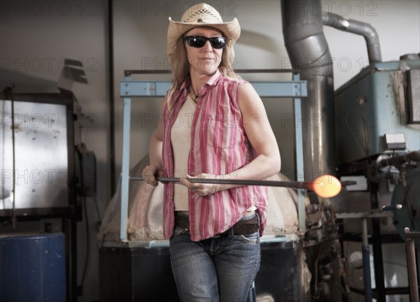 Caucasian woman in glass blowing studio