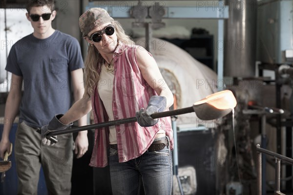 Caucasian woman in glass blowing studio