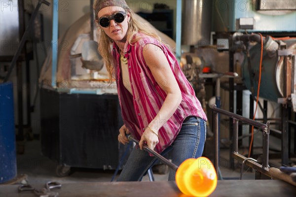 Caucasian woman in glass blowing studio