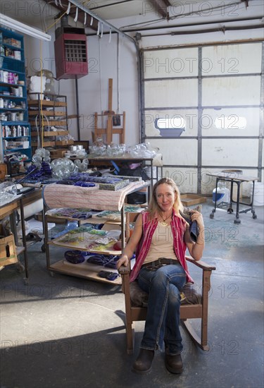 Caucasian woman in glass blowing studio