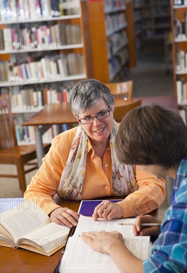 Librarian helping student in library