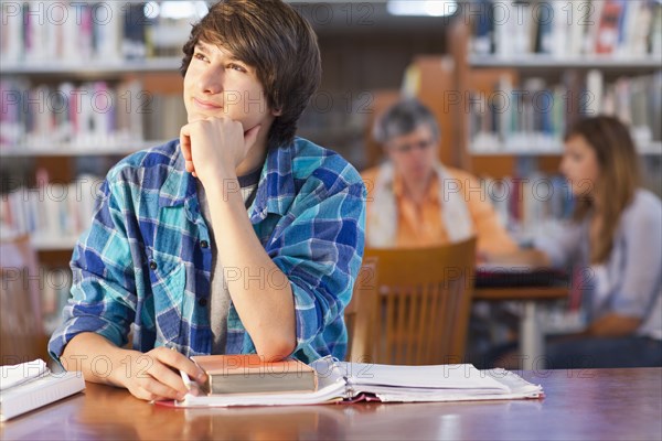 Student daydreaming in library