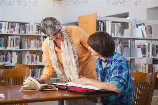 Librarian helping student in library