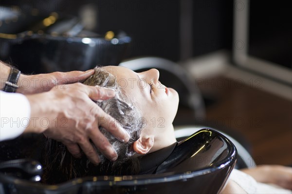 Woman having her hair washed in salon