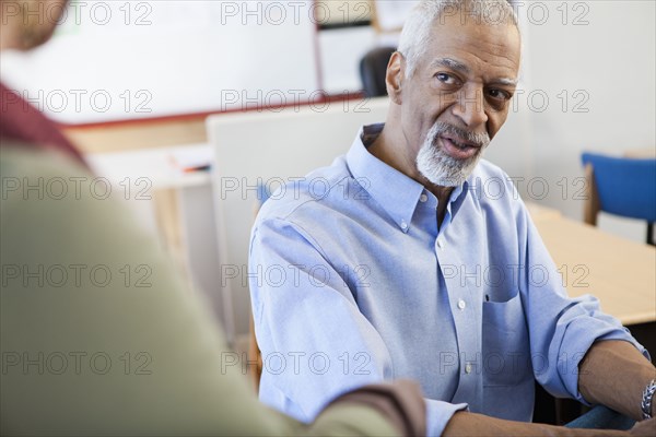 Teacher and student talking in classroom