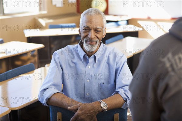 Black teacher sitting in classroom