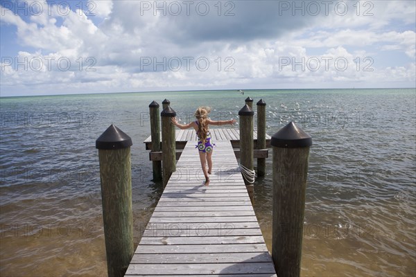 Caucasian girl walking on pier