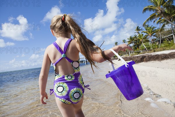 Caucasian girl walking on beach