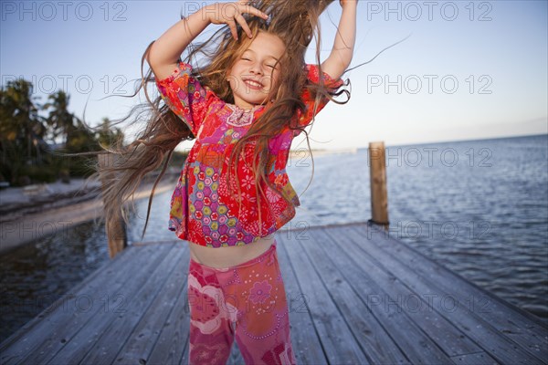 Caucasian girl dancing on pier