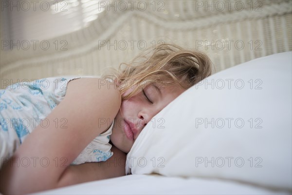 Caucasian girl sleeping in bed