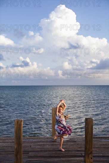 Caucasian girl dancing on pier