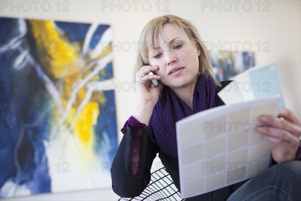 Caucasian art gallery owner talking on cell phone