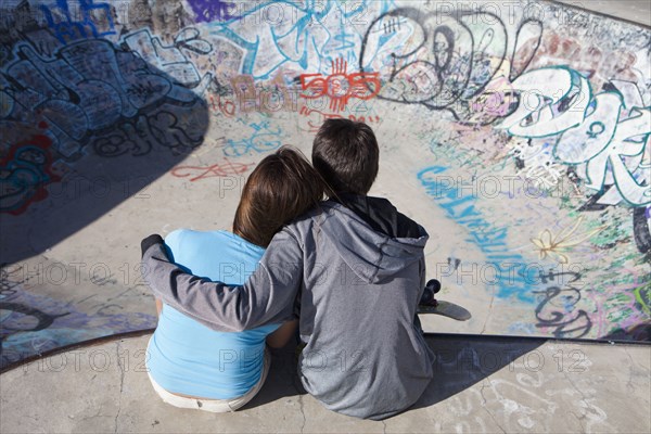 Boy and girl hugging in skateboard park