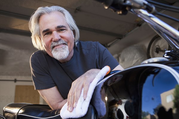 Caucasian man cleaning motorcycle