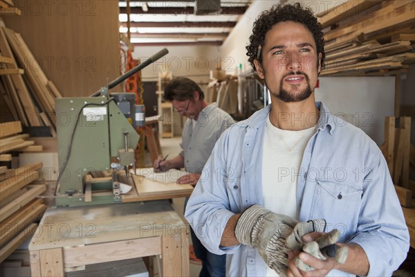 Co-workers woodworking in workshop