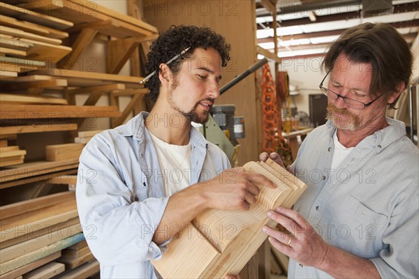 Co-workers woodworking in workshop