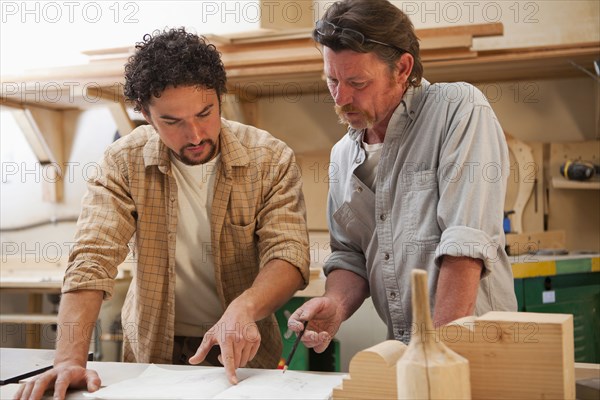 Co-workers woodworking in workshop