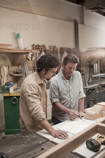 Co-workers woodworking in workshop