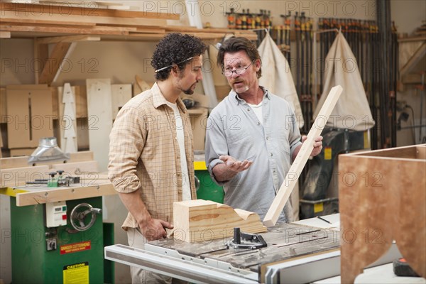 Co-workers woodworking in workshop