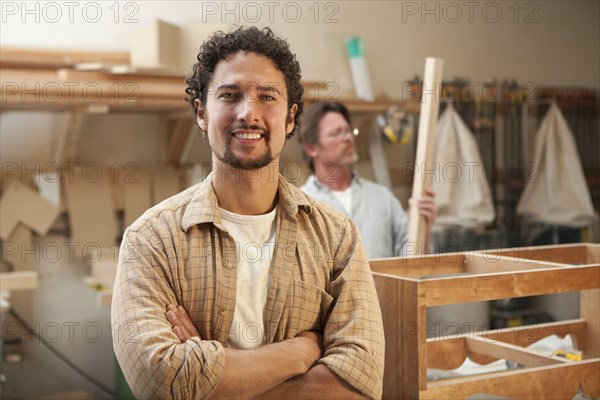 Co-workers woodworking in workshop