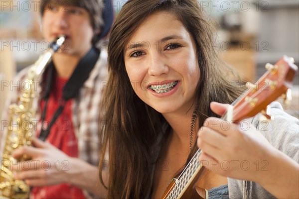 Mixed race girl playing guitar