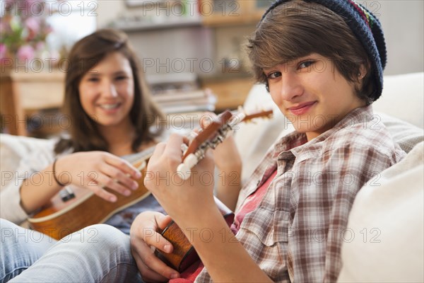 Mixed race friends playing ukulele