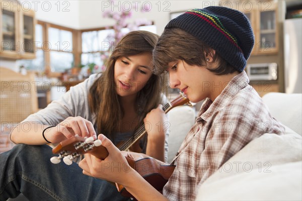 Mixed race friends playing ukulele