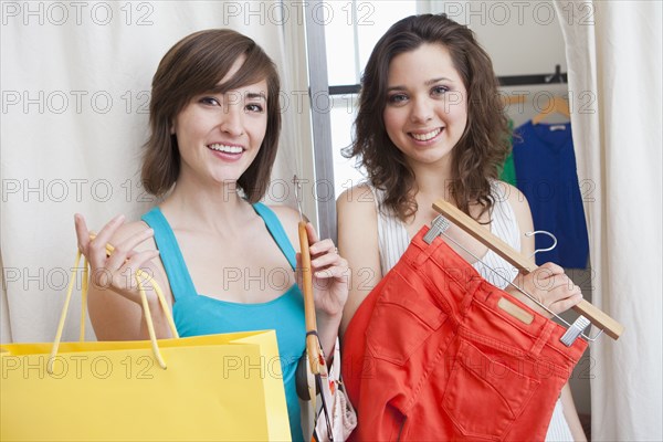 Hispanic friends shopping in clothing store