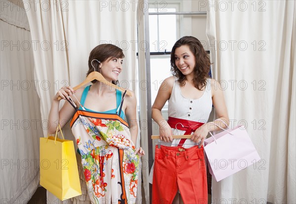 Hispanic friends shopping in clothing store