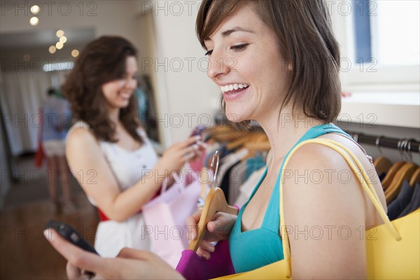 Hispanic friends shopping in clothing store