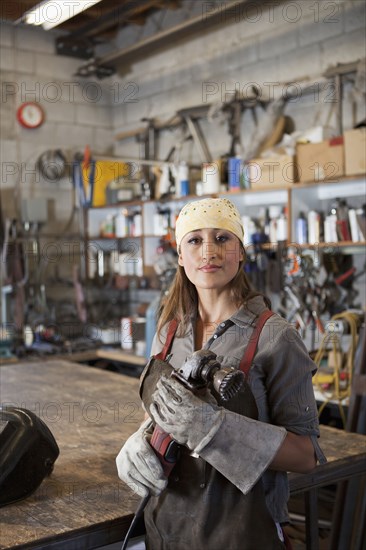 Hispanic factory worker holding metal fabricator