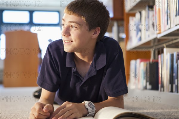 Caucasian boy reading book in library