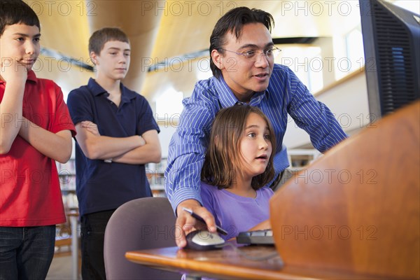 Teacher showing student how to use computer