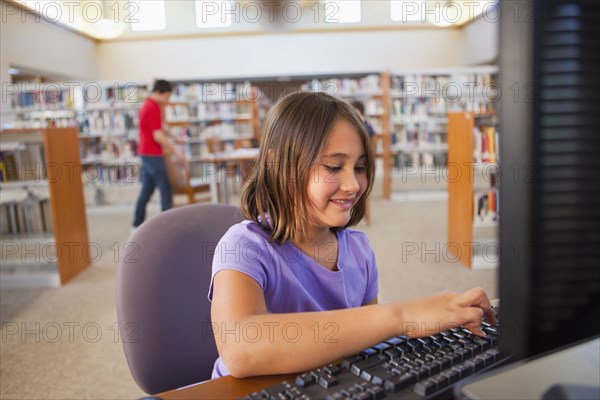 Girl using computer in library