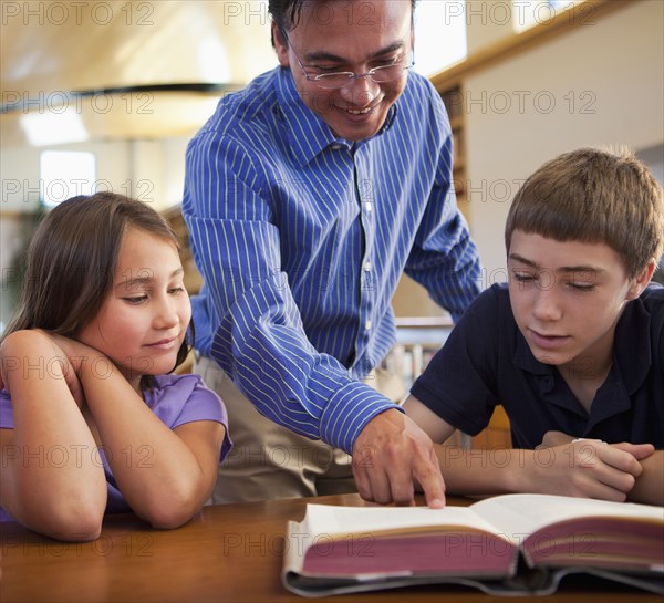 Teacher talking to students in library