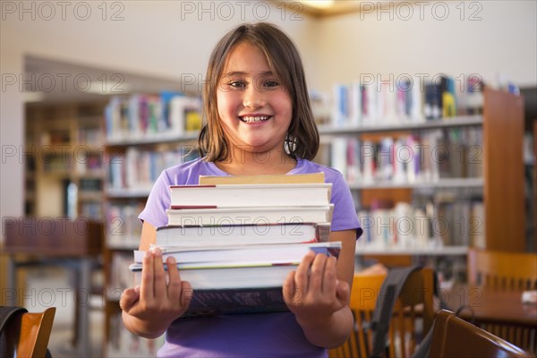 Mixed race girl carrying library books