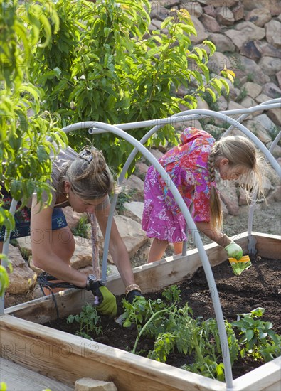 Caucasian mother and daughter gardening together