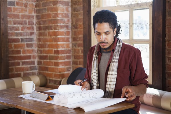 Mixed race businessman working in coffee shop