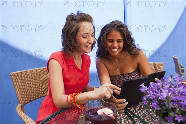 Friends looking at digital tablet together