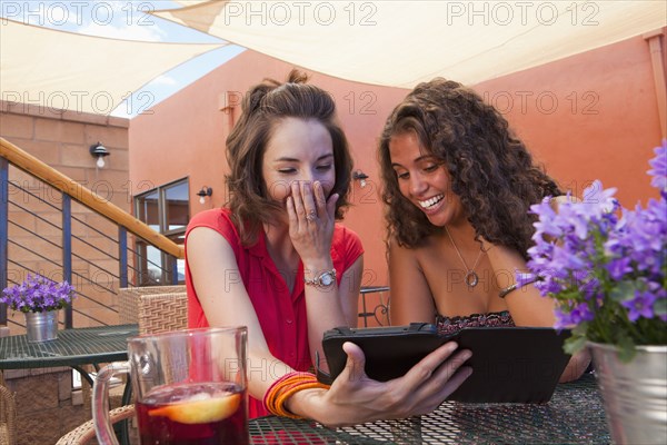 Friends looking at digital tablet together