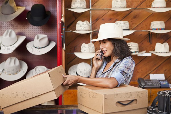 Ecuadorian woman talking on cell phone in hat store