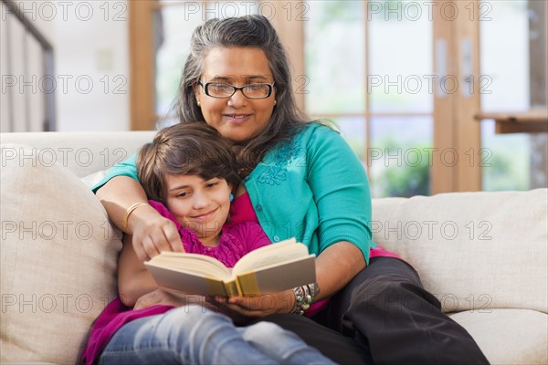 Mother and daughter reading book together