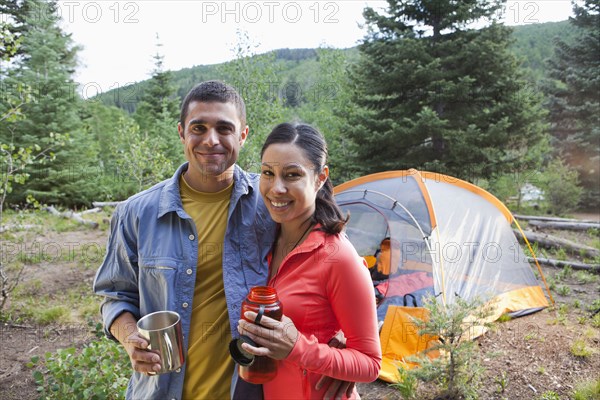 Smiling couple camping together