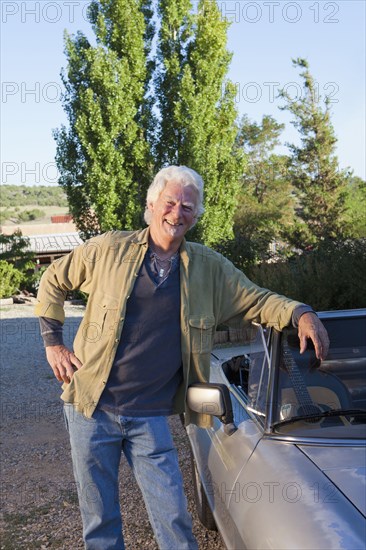 Caucasian man leaning on convertible