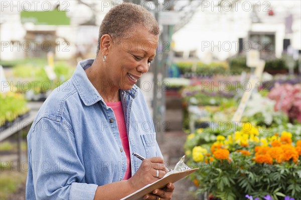 Mixed race woman working in plant nursery